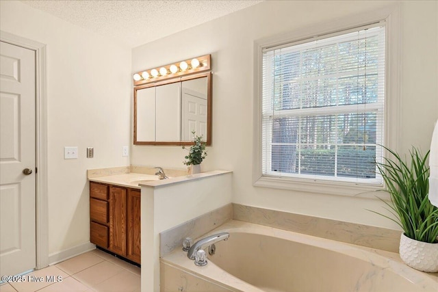 full bathroom featuring a textured ceiling, vanity, tile patterned flooring, baseboards, and a bath