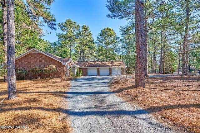 view of front of property featuring a garage, driveway, and brick siding