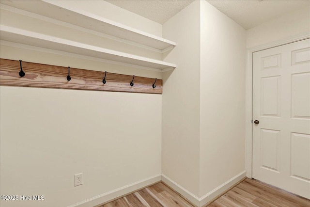 mudroom featuring light wood-type flooring and baseboards