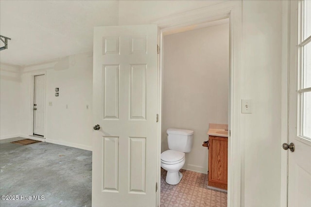 bathroom featuring baseboards, vanity, and toilet