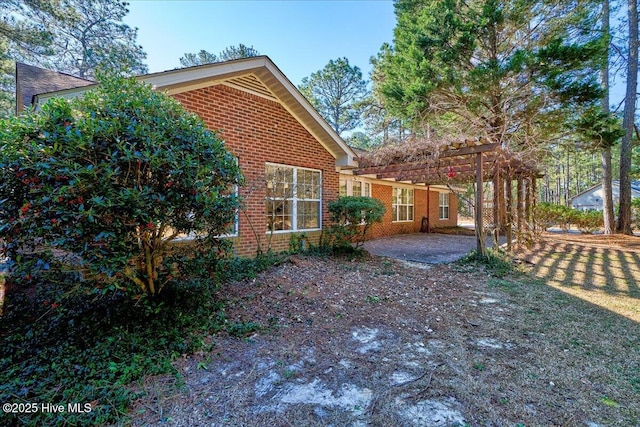 rear view of house with a patio area and brick siding