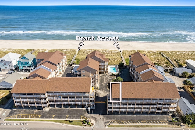 drone / aerial view featuring a beach view and a water view