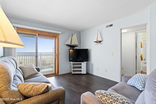 living area with visible vents, a textured ceiling, and baseboards