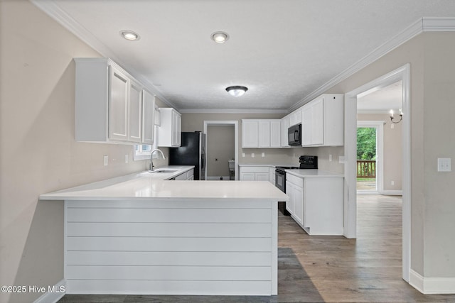 920 Shelter Creek Dr, Burgaw, NC 28425 - kitchen with a peninsula, a sink, baseboards, black appliances, and ornamental molding
