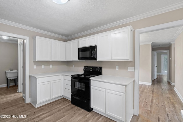 920 Shelter Creek Dr, Burgaw, NC 28425 - kitchen featuring black appliances, light wood-style floors, light countertops, and white cabinets