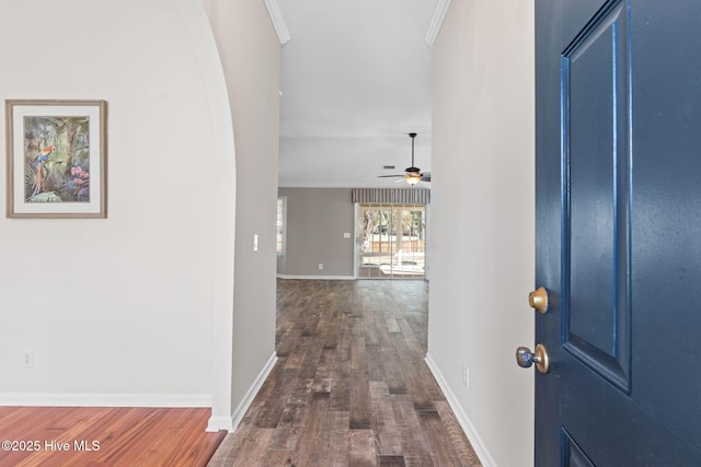 foyer entrance with ornamental molding, dark wood-style flooring, and baseboards