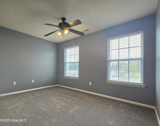 empty room featuring baseboards, visible vents, carpet floors, and a textured ceiling