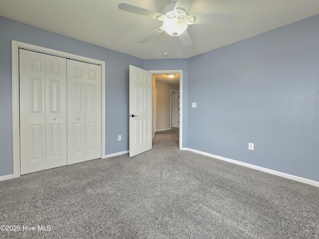 unfurnished bedroom featuring baseboards, carpet flooring, a closet, a textured ceiling, and a ceiling fan