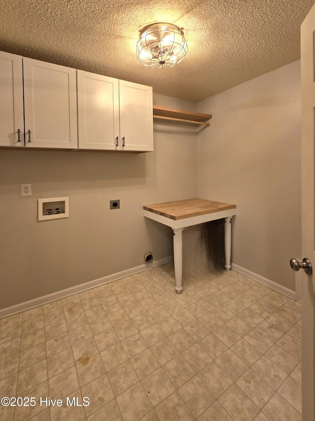 washroom featuring electric dryer hookup, a textured ceiling, cabinet space, baseboards, and hookup for a washing machine