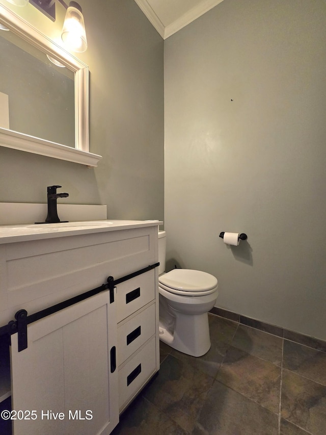 bathroom featuring vanity, toilet, crown molding, and baseboards