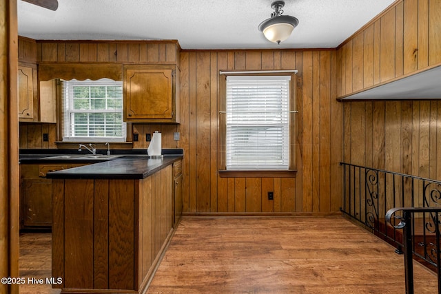 211 Brandon Ave, Tarboro, NC 27886 - kitchen with a peninsula, wood finished floors, a sink, brown cabinetry, and dark countertops