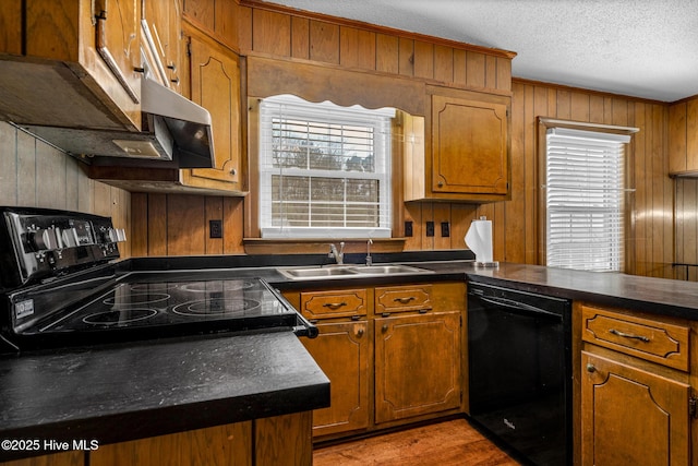 211 Brandon Ave, Tarboro, NC 27886 - kitchen with dark countertops, brown cabinetry, a sink, wooden walls, and black appliances