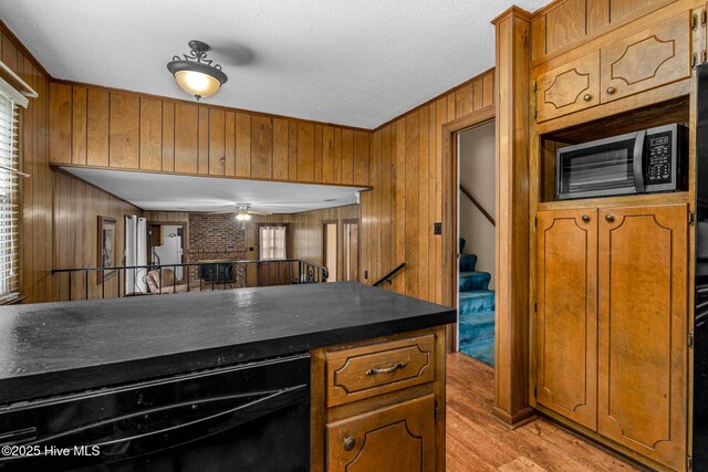 211 Brandon Ave, Tarboro, NC 27886 - kitchen with dark countertops, a brick fireplace, light wood-style flooring, and brown cabinetry