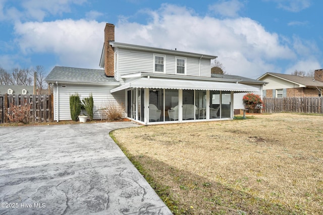 211 Brandon Ave, Tarboro, NC 27886 - rear view of property featuring a yard, a chimney, fence, and a sunroom