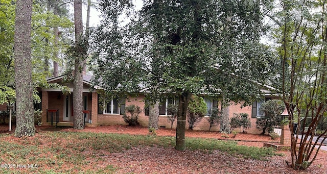 view of front of home featuring brick siding and crawl space