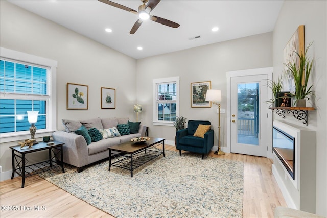 living room with light wood-style floors, recessed lighting, visible vents, and baseboards