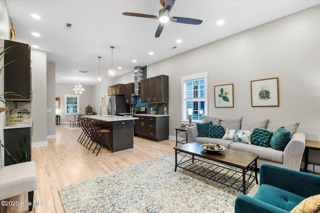 living room with light wood-style floors, recessed lighting, visible vents, and baseboards