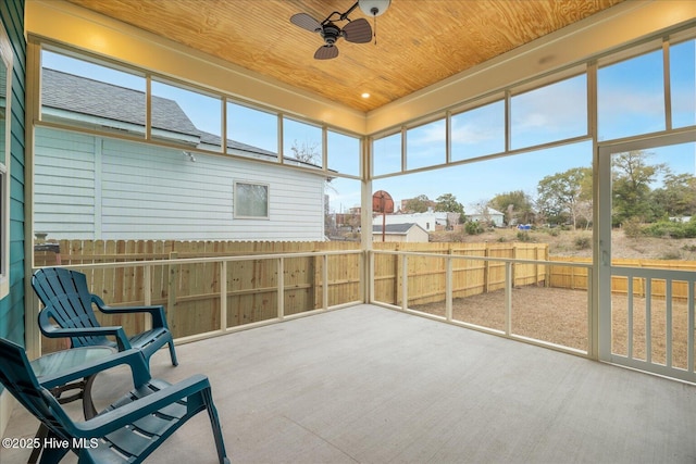 sunroom featuring a ceiling fan and wood ceiling