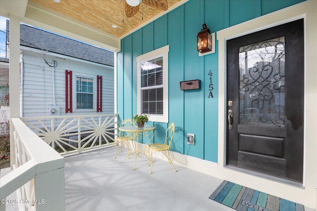 property entrance with covered porch, a ceiling fan, and board and batten siding