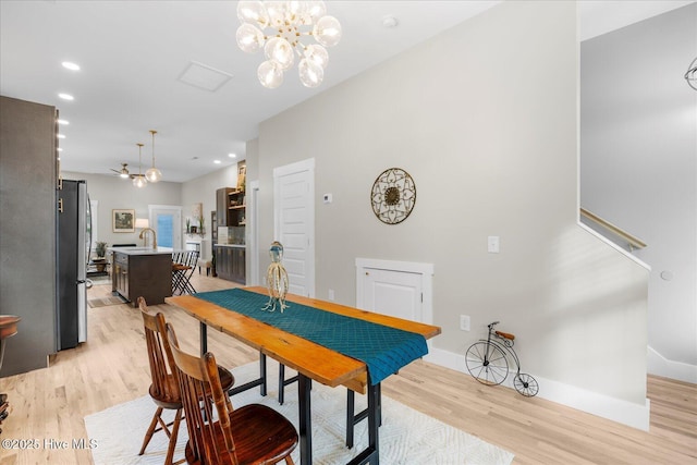 dining room featuring light wood-type flooring, an inviting chandelier, baseboards, and recessed lighting