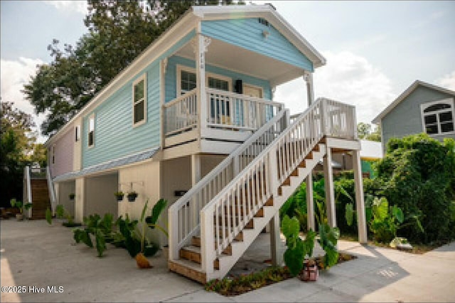 coastal home featuring covered porch and stairs