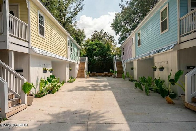 view of side of property featuring stairs, a patio, and a balcony