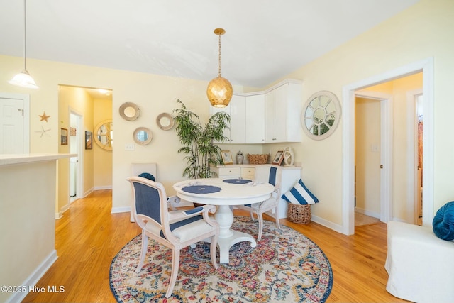 dining room featuring light wood-style floors and baseboards