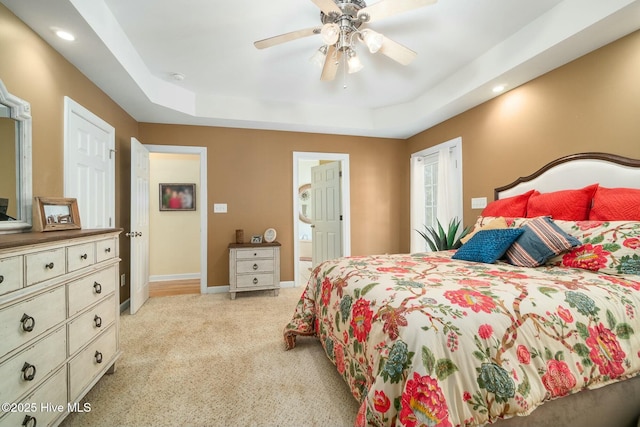 bedroom with a tray ceiling, baseboards, carpet floors, and ceiling fan