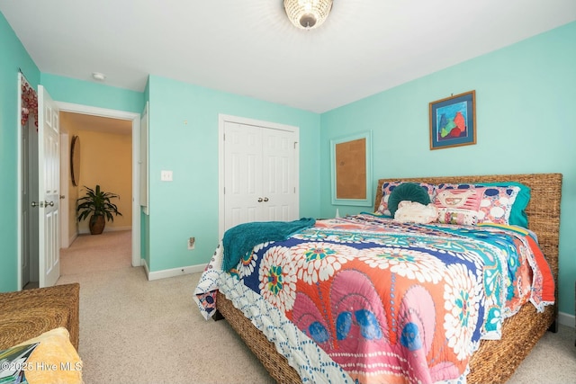 bedroom with carpet flooring, baseboards, and a closet