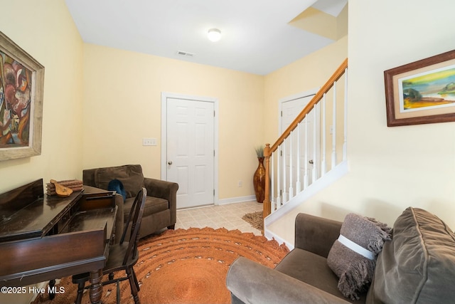 living room featuring stairs, baseboards, and visible vents