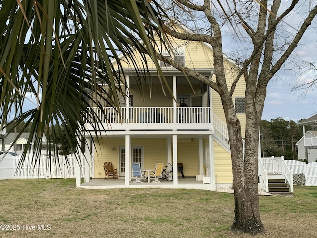 rear view of property with a patio, a lawn, and fence