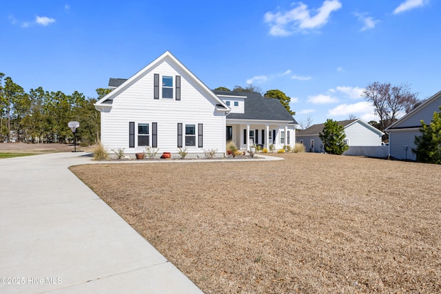 view of front of property with a shingled roof and a front lawn