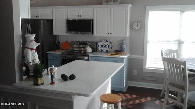 kitchen featuring stainless steel appliances, light countertops, and white cabinets