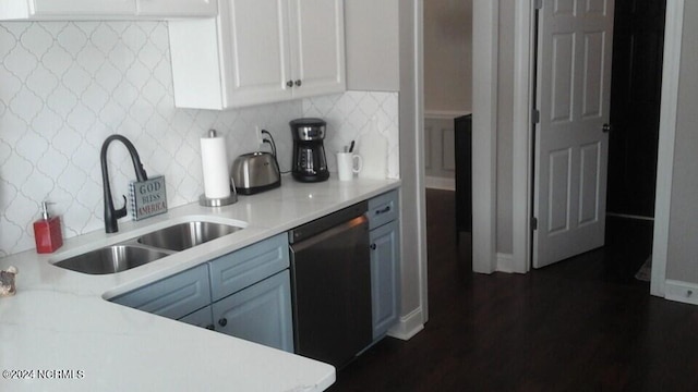 kitchen featuring a sink, white cabinetry, light countertops, dishwasher, and tasteful backsplash