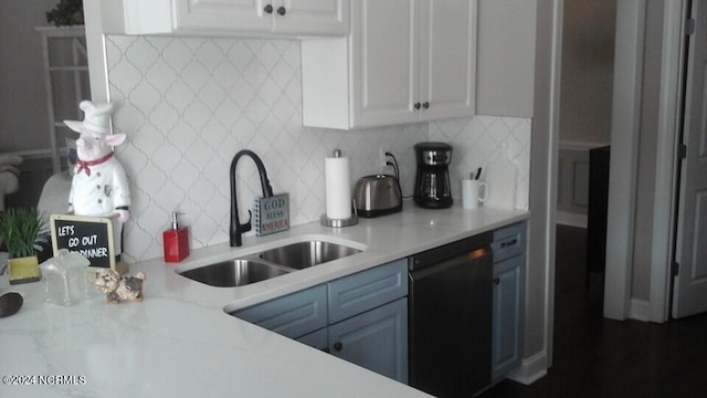 kitchen featuring black dishwasher, tasteful backsplash, blue cabinetry, white cabinetry, and a sink