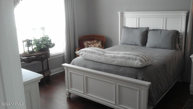 bedroom with dark wood-style floors and baseboards