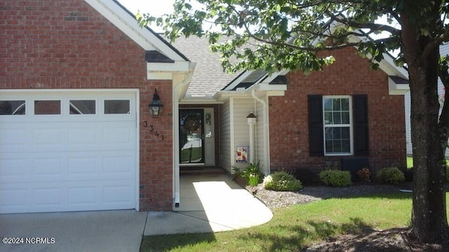 property entrance featuring a garage and brick siding