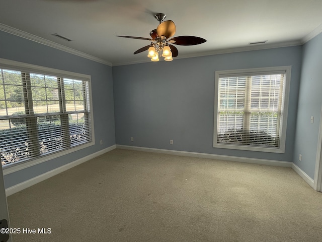 empty room with plenty of natural light, visible vents, and crown molding