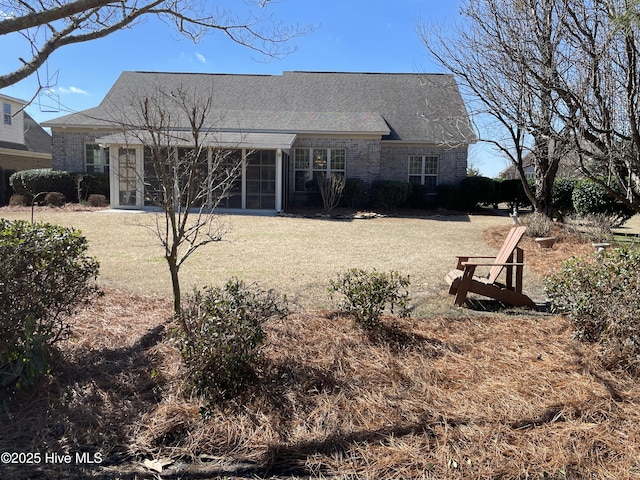 rear view of property with a sunroom and a lawn