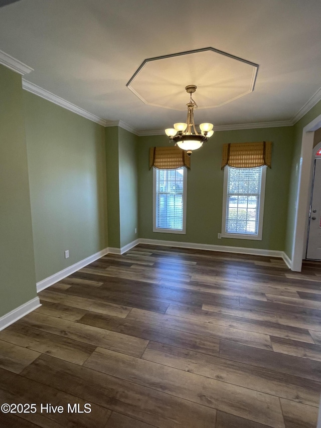 unfurnished room featuring crown molding, a chandelier, dark wood finished floors, and baseboards