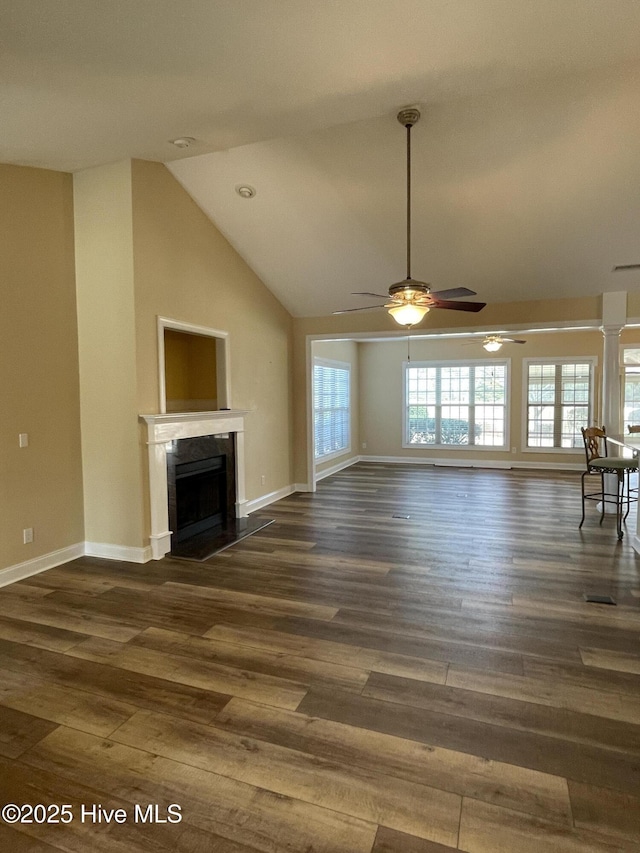 unfurnished living room featuring a fireplace, baseboards, and wood finished floors