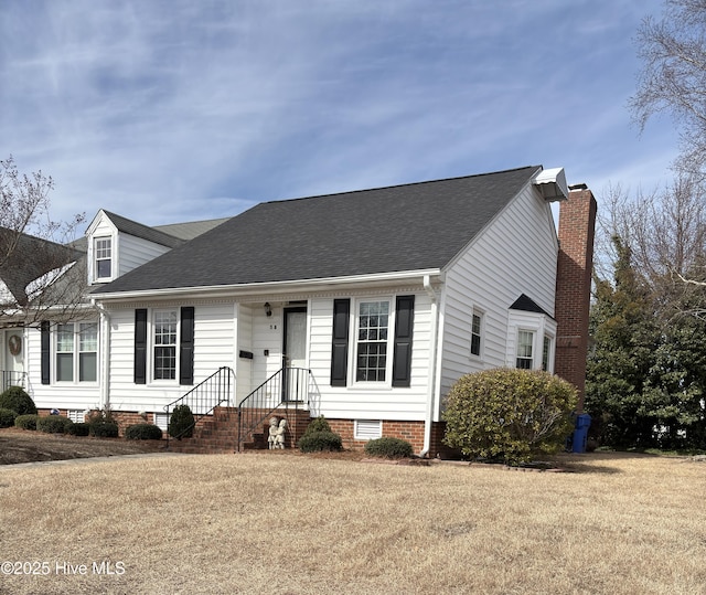 view of front of house with a shingled roof, crawl space, a chimney, and a front lawn