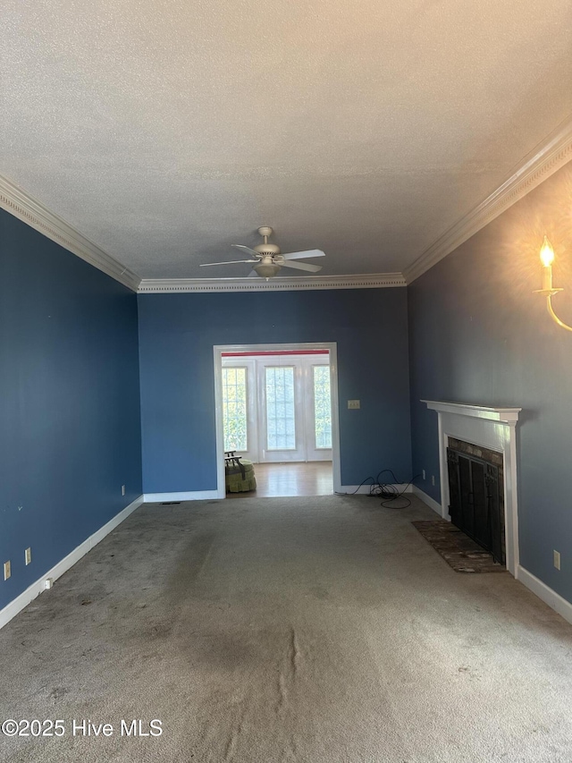 unfurnished living room with carpet, a fireplace, ornamental molding, a textured ceiling, and baseboards