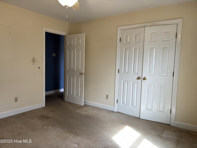 unfurnished bedroom featuring baseboards, a closet, and light colored carpet