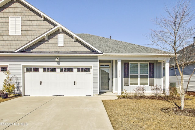 view of front of home featuring driveway, a shingled roof, and an attached garage