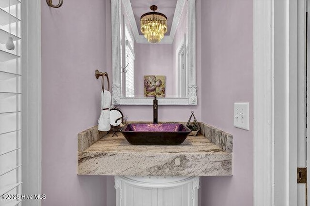 bathroom featuring a chandelier and a sink