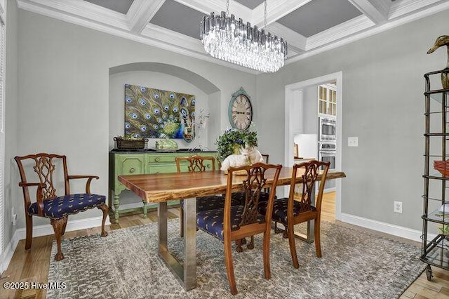 dining space with a notable chandelier, light wood-style floors, ornamental molding, coffered ceiling, and baseboards