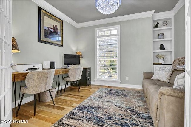 office with baseboards, wood finished floors, an inviting chandelier, crown molding, and built in shelves