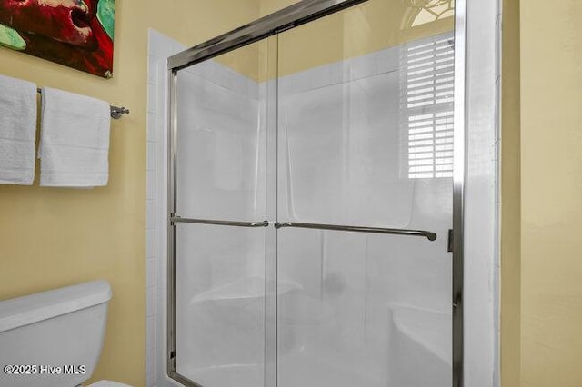 bathroom featuring toilet and an enclosed shower