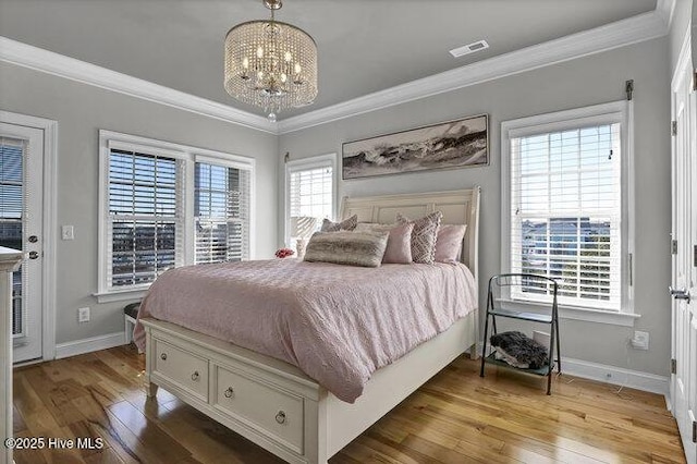 bedroom with ornamental molding, light wood-type flooring, a notable chandelier, and baseboards